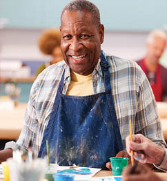 A man and woman are painting at an easel, with the man wearing a blue shirt and the woman wearing a red shirt. They are both smiling as they create their art. AI generated content