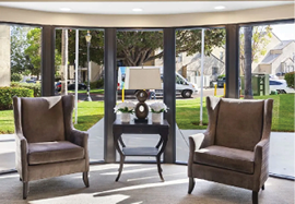 A living room with two chairs, a coffee table, and a sliding glass door. AI generated content
